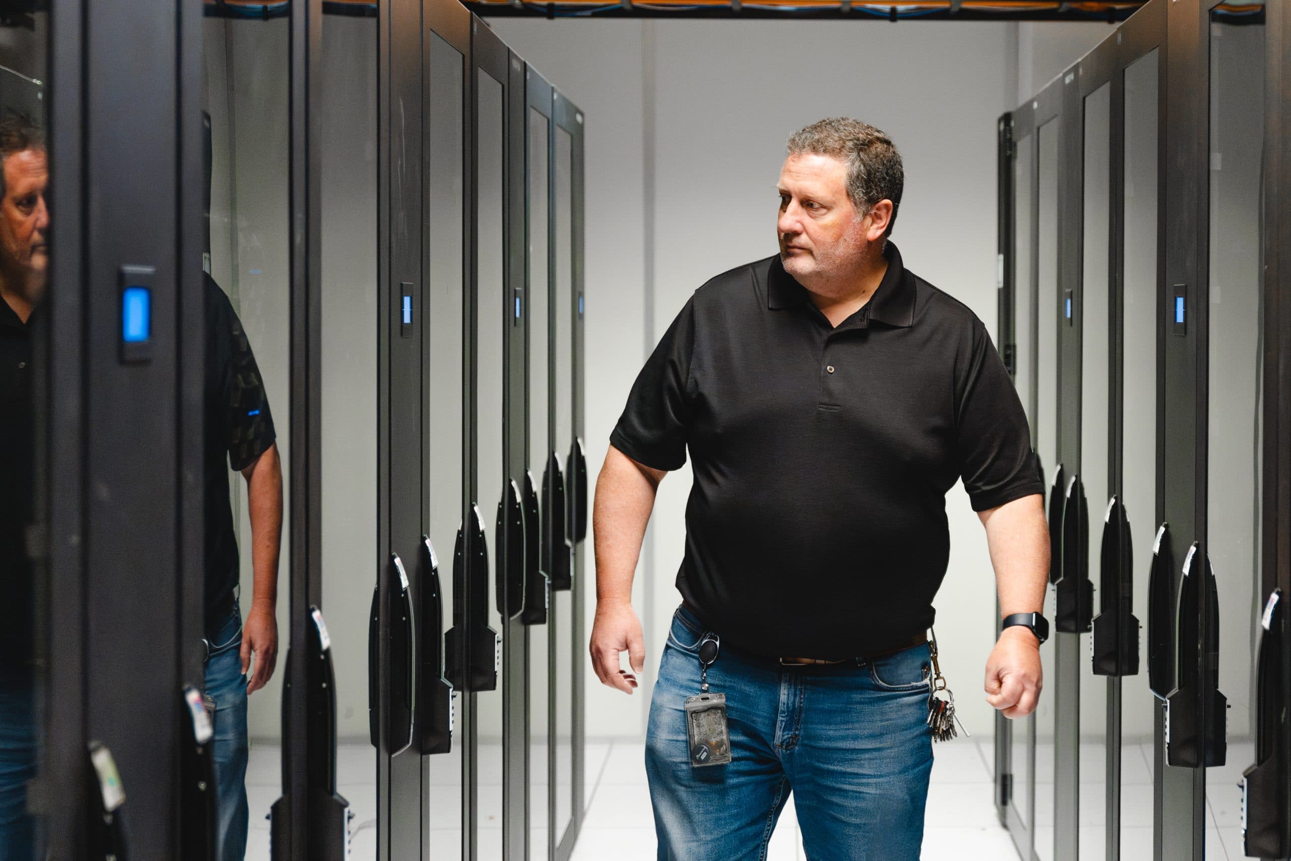 Engineer walking through server racks in a data center